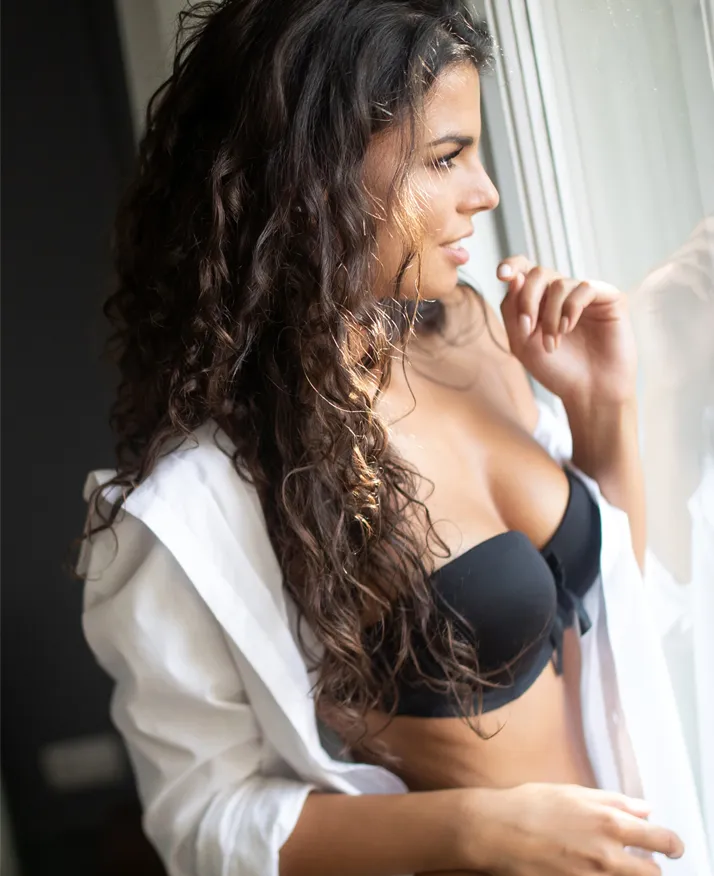 Brunette woman looking out window - Breast Reduction