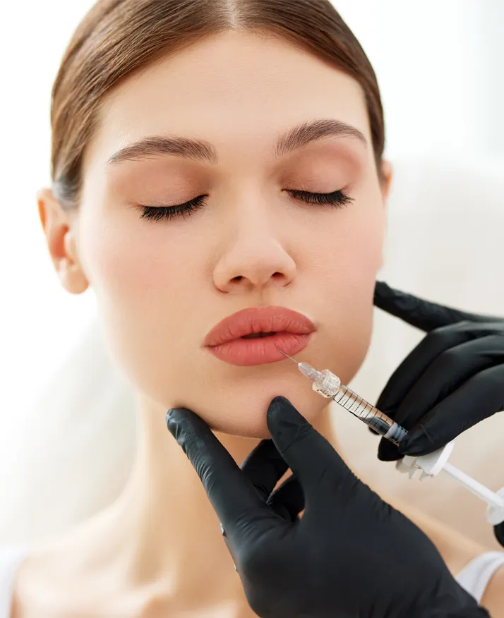 Close up of woman getting needle injection in lips - Lip Fillers
